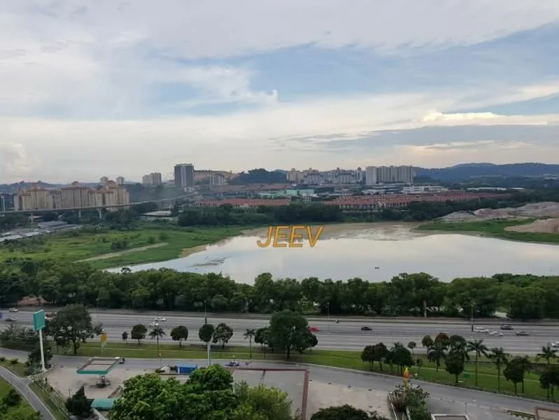 Exterior features: city skyline in background, lake or pond visible, greenery along the water's edge, road with vehicles in foreground, urban landscape with buildings, hills in distance, cloudy sky.