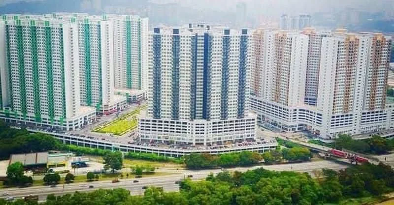 Exterior type: high-rise condominium; features: glass curtain wall, green accent panels, multiple residential towers, surrounding greenery, parking area visible, adjacent to main road; style: modern.