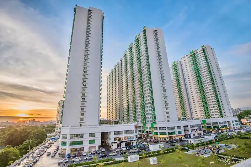 Exterior type: high-rise condominium; features: green and white facade, multiple towers, ground-level retail spaces, parking area, sunset view, landscaped surroundings, balconies on upper floors, large windows, modern architectural design; style: modern.