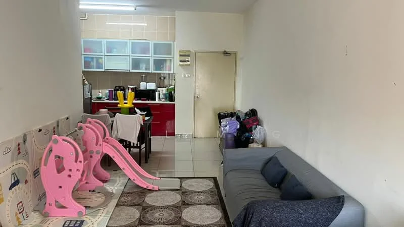 Living features: grey fabric sofa, area rug with circular pattern, white painted walls, tile flooring, wall-mounted light fixture, sliding door, children's play equipment, dining table with chairs, kitchen area visible in background, kitchen cabinetry in red, kitchen countertop, kitchen appliances visible.