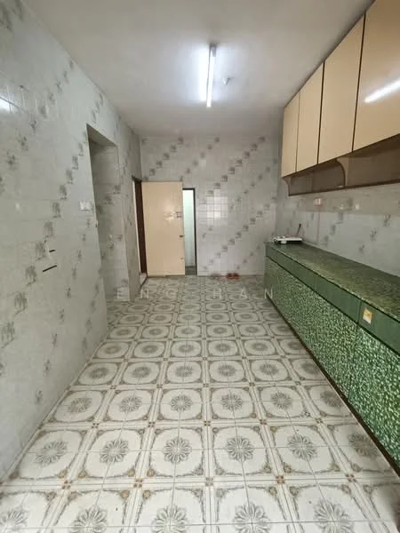 Kitchen features: green patterned cabinetry, white tiled walls, grey tiled flooring with floral pattern, fluorescent ceiling lights, built-in countertop, single-bowl sink, wall-mounted cabinets, doorway leading to another room.