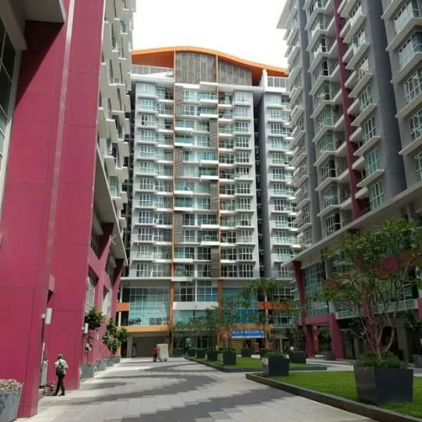 Exterior type: high-rise condominium; features: glass curtain wall, pink painted facade, orange accent elements, multiple balconies, manicured lawn, landscape planters, paved walkway, surrounded by greenery; style: modern.