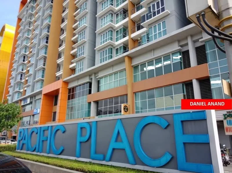 Exterior type: high-rise condominium; features: glass curtain wall, orange and grey facade, large windows, prominent signage, manicured landscaping, entrance with awning; style: modern.
