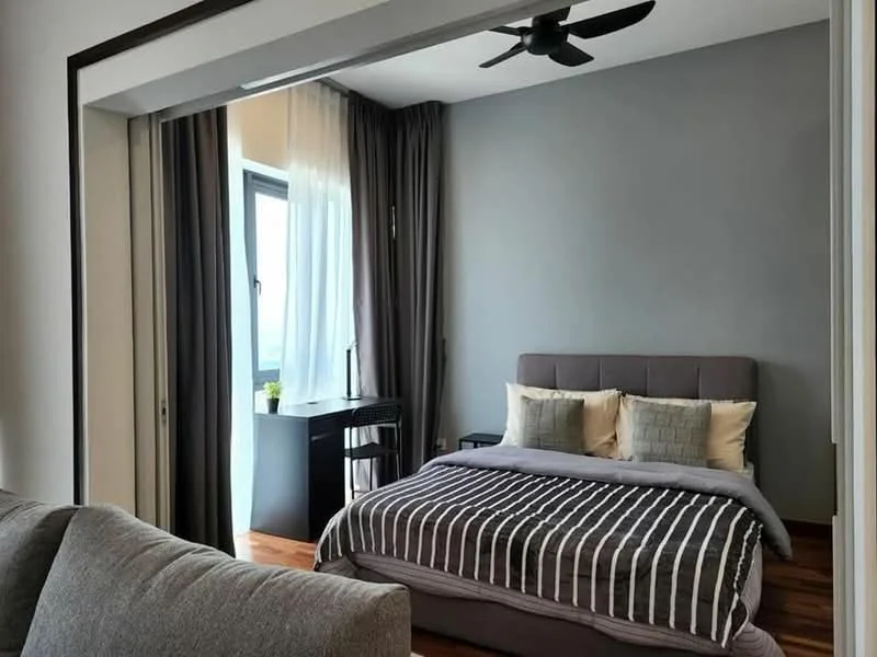 Bedroom features: king-size bed with grey upholstered headboard, striped bedding in grey and white, 2 decorative pillows in cream and grey, wooden flooring, floor-to-ceiling window, sheer curtains, dark grey accent wall, ceiling fan with light, small study desk, black chair; style: modern; view: city.