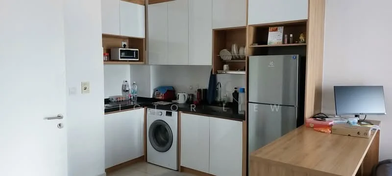 Kitchen features: white upper cabinets, wood lower cabinets, black countertop, built-in microwave, stainless-steel fridge, front-load washing machine, kitchen sink, dish rack, open shelving, kitchen utensils, monitor on countertop; style: modern.