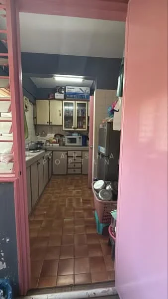 Kitchen features: brown tiled flooring, light wood cabinetry, grey countertop, stainless-steel fridge, built-in oven, microwave, double-bowl stainless-steel sink, chrome pull-down faucet, wall-mounted shelves, window above sink, open shelving, kitchen utensils visible, dish rack, storage baskets.