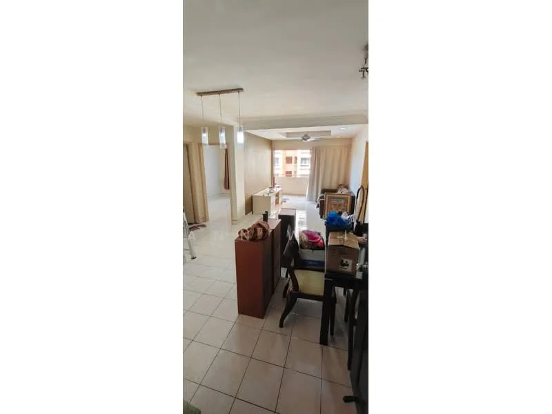 Living features: cream painted walls, tile flooring, ceiling fan, large windows with sheer curtains, dining table with chairs, wooden sideboard, boxes and miscellaneous items, open layout to adjacent room.