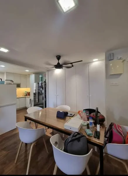 Dining features: wooden dining table, 4 white plastic dining chairs, ceiling fan with light, recessed downlights, built-in white cabinetry, kitchen area visible in background, wooden flooring, wall-mounted storage unit; style: modern.