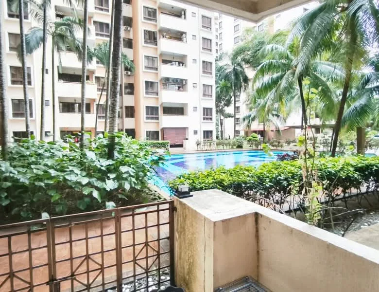 Room features: balcony with railing, view of swimming pool, view of landscaped garden, potted plants, palm trees, concrete flooring, surrounding greenery, building facade in background; style: modern; view: pool.