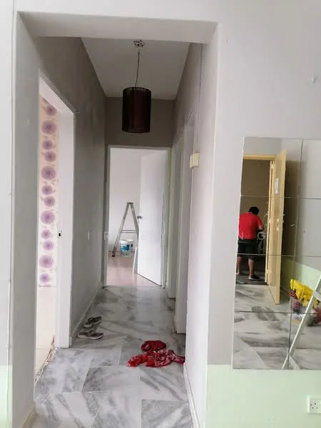 Hallway features: grey painted walls, marble tile flooring, ceiling light fixture, mirror on wall, doorway leading to other rooms, ladder visible, unfinished wall with paint, flooring transition at base.