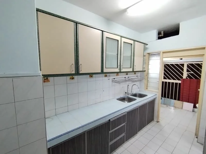 Kitchen features: light blue painted walls, white tiled backsplash, light grey countertop, double-bowl stainless-steel sink, chrome faucet, wood cabinetry with glass inserts, dark wood lower cabinets, white tiled flooring, window with security bars, door leading to outdoor area; style: modern.