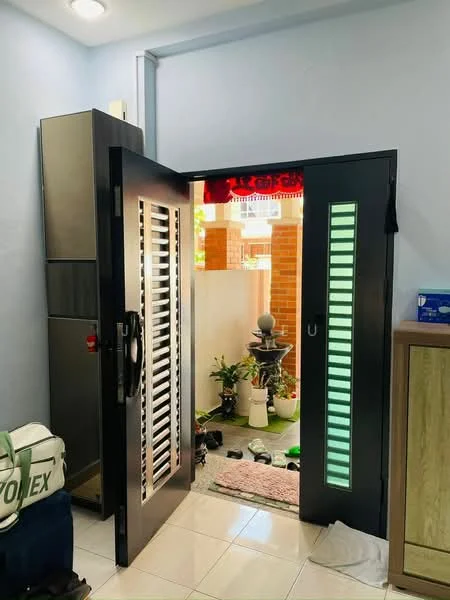 Room features: black double door with glass panels, white walls, ceramic tile flooring, refrigerator, decorative indoor fountain, potted plants, outdoor view through door, light fixture on ceiling; style: modern; view: garden.