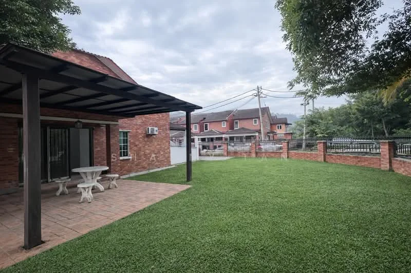 Exterior type: detached bungalow; features: brick facade, covered patio with roof, outdoor dining table, manicured lawn, fenced perimeter, paved walkway, surrounded by greenery, city skyline in background; style: modern.
