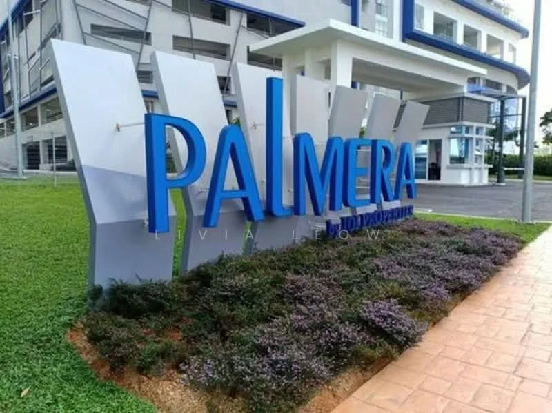 Exterior features: landscaped garden with low shrubs, large blue sign with the name 'PALMERA', modern architectural design, paved walkway, green lawn area, building facade in light grey and blue, covered entrance area; style: modern.