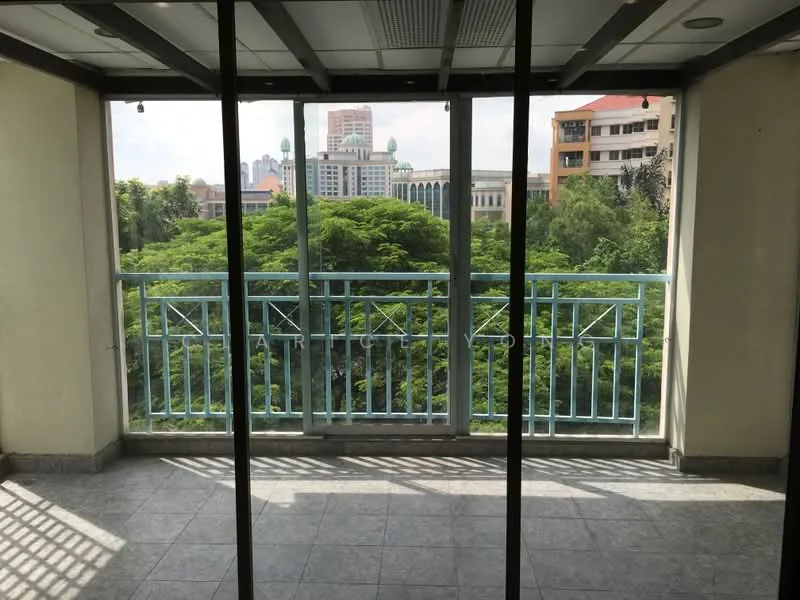 Room features: floor-to-ceiling windows, sliding glass door, grey tiled flooring, balcony with railing, view of greenery, city skyline in background, overhead ceiling lights, open layout; style: modern; view: garden.