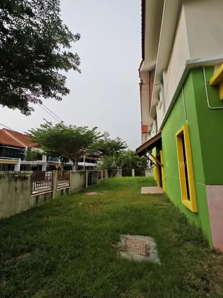 Exterior type: linked terrace house; features: green painted facade, yellow window frames, manicured lawn, mature trees, concrete pathway, two-storey building, fenced boundary, adjacent to residential street; style: modern.