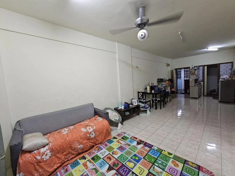 Living features: grey fabric sofa, orange floral throw blanket, colorful area rug with letters, white painted walls, glossy tile flooring, ceiling fan with light, wooden shelving unit, kitchenette area with appliances, refrigerator, microwave, kettle, dining table, open layout.