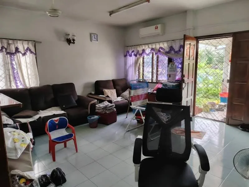 Living features: 3-seater fabric sofa in dark brown, 2-seater fabric sofa in dark brown, plastic chair in red and blue, plastic laundry basket, ceiling fan, air conditioning unit, tile flooring in light blue, curtains with purple trim, wooden door with glass panel, wall-mounted clock, decorative wall sconce, open doorway leading outside; view: garden.