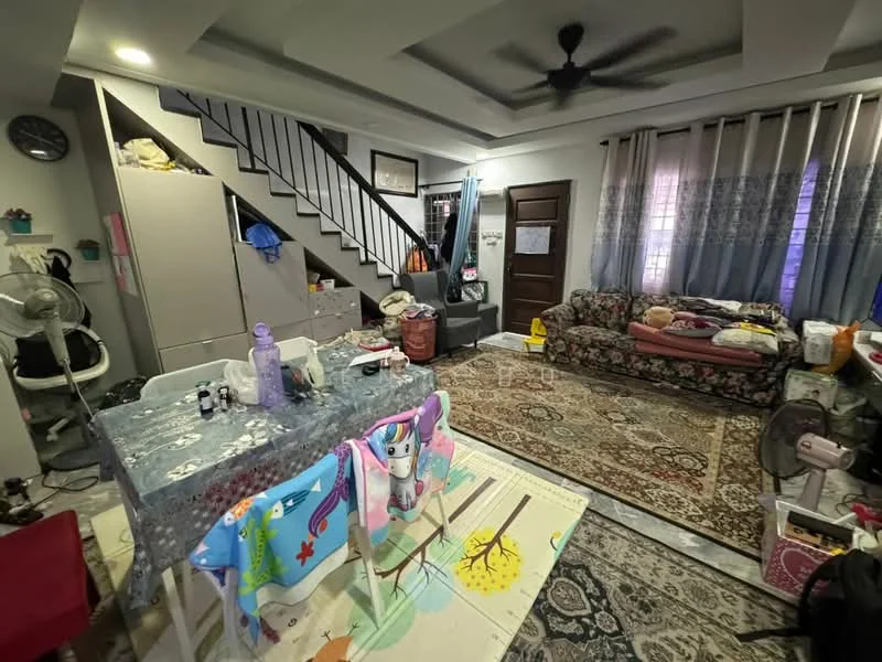 Living features: sofa with floral pattern, area rug with intricate design, ceiling fan, wall-mounted clock, dining table with tablecloth, staircase leading to upper level, curtains with blue and white pattern, wall with wooden door, decorative wall art, open shelving unit, fan on floor, storage cabinets, various decorative items; style: traditional.