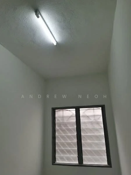 Room features: white painted walls, ceiling with textured finish, fluorescent light fixture, sliding window with grille, grey window frame.