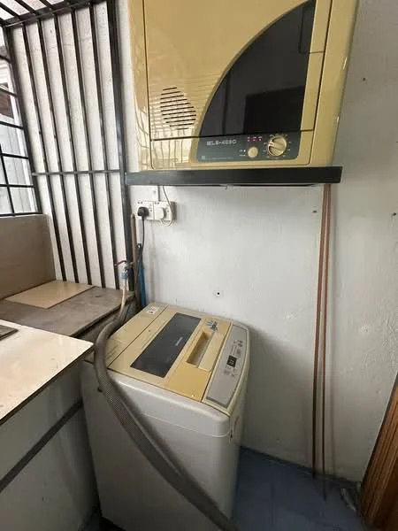 Laundry features: top-load washing machine in white, dryer mounted on wall, grey hose connected to washing machine, white walls, blue vinyl flooring, metal window bars, shelf above washing machine.