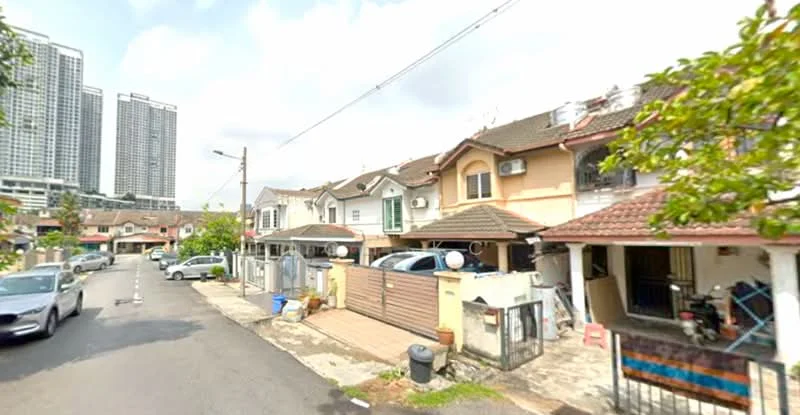 Exterior type: linked terrace house; features: two-storey linked terrace houses, red tiled roof, cream painted facade, front porch with gate, driveway with interlocking pavers, visible air conditioning units, street view with parked cars, mature trees along the street, surrounded by high-rise buildings; style: modern.