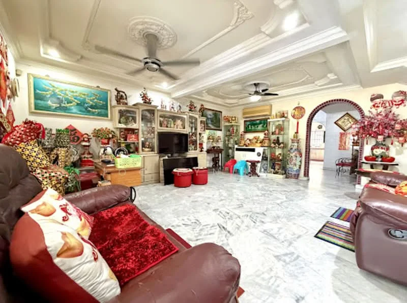 Living features: marble flooring, tray ceiling with decorative moulding, 5-blade ceiling fan, wall-mounted TV, wooden TV console, decorative shelves with collectibles, red and gold decorative accents, sofa with red cushions, colorful area rug, large windows with natural light, wall art and paintings, open layout to adjacent room; style: traditional.