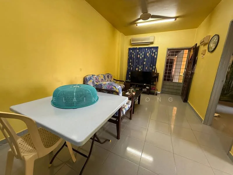 Living features: yellow painted walls, glossy tile flooring, 5-blade ceiling fan, sofa with floral pattern, TV console, wall-mounted TV, curtains with floral pattern, dining table with chairs, air conditioning unit.