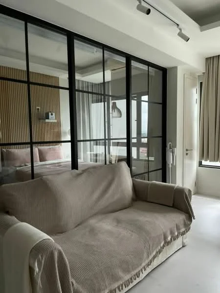 Living features: fabric sofa in beige, glass partition wall, white walls, recessed ceiling lights, curtains in light fabric, wood paneling on wall, floor-to-ceiling windows, neutral flooring; style: modern; view: city.
