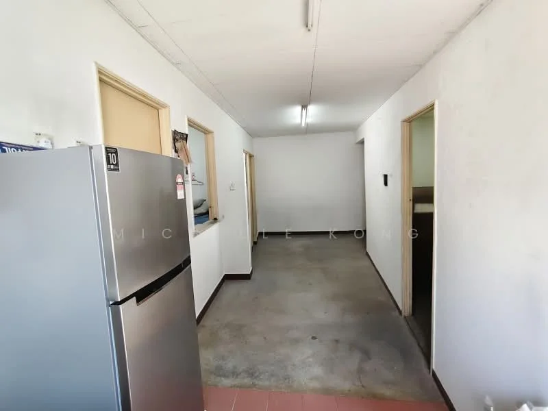 Room features: grey concrete flooring, white painted walls, two wooden doors, one wall-mounted intercom, refrigerator, fluorescent ceiling lights.