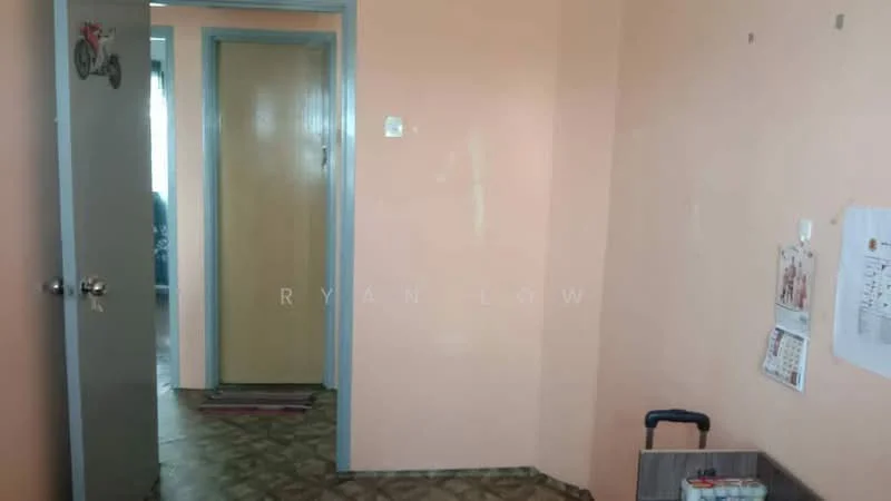 Room features: peach painted walls, vinyl flooring, wooden door, grey door frame, light coming from window, calendar on wall, trolley, rug at entrance.