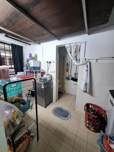 Kitchen features: tile flooring, white walls, wooden ceiling, stainless-steel fridge, sink, wall-mounted cabinets, countertop, laundry basket, storage cart, window with black curtains, doorway to utility area.