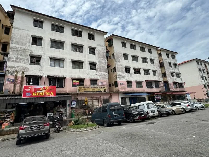 Exterior type: low-rise apartment block; features: white painted facade, multiple storey building, ground floor commercial units, visible parking area, windows with metal grilles, signage for businesses, asphalt parking lot, surrounding residential area; style: traditional.