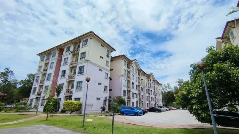 Exterior type: low-rise apartment block; features: cream painted facade, pink accent wall, 3-storey building, landscaped garden, mature trees, open-air parking lot, surrounded by greenery, balconies on upper floors, multiple windows, visible air conditioning units; style: modern.
