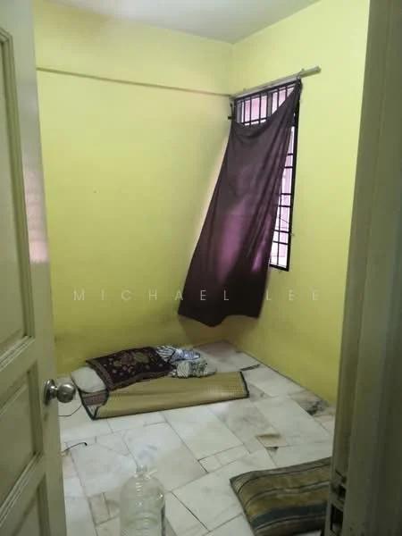 Room features: yellow painted walls, marble tile flooring, window with black curtain, mattress on the floor, bedding on the floor, plastic water container.