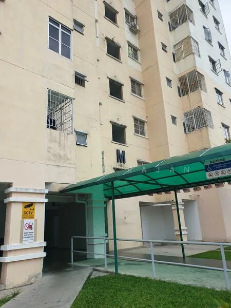 Exterior type: low-rise apartment block; features: cream painted facade, ground floor entrance with awning, CCTV camera visible, manicured lawn, multiple windows with metal grilles, signage with letter 'M', covered walkway, parking area visible; style: modern.