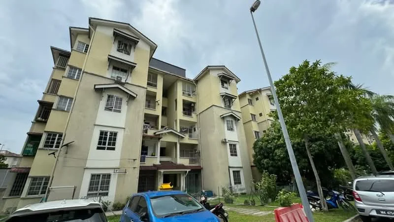 Exterior type: low-rise apartment block; features: cream painted facade, balconies with railings, multiple storeys, landscaped garden area, parking spaces visible, surrounded by greenery, street lamp, motorcycles parked, windows with grilles; style: modern.