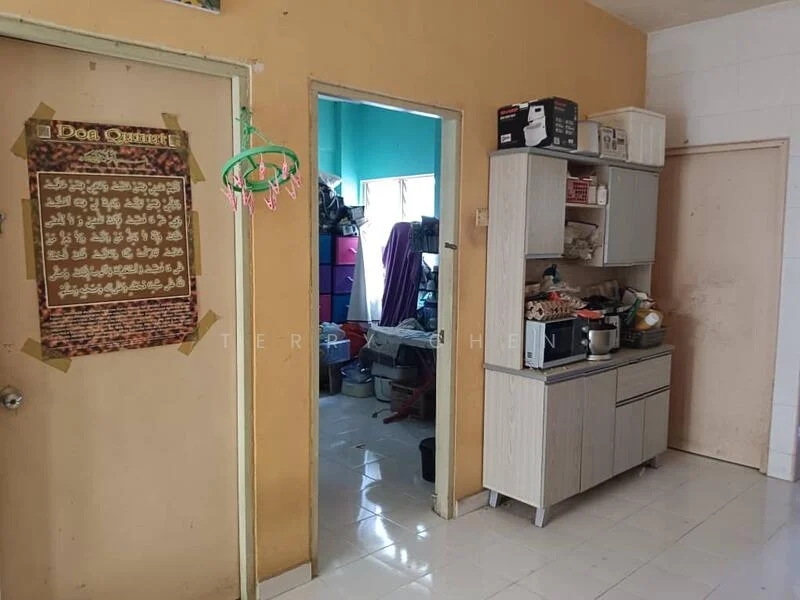 Kitchen features: white tiled flooring, orange painted walls, wooden cabinetry, countertop with appliances, sink, wall-mounted shelf, door leading to another room, window with natural light, decorative wall hanging.