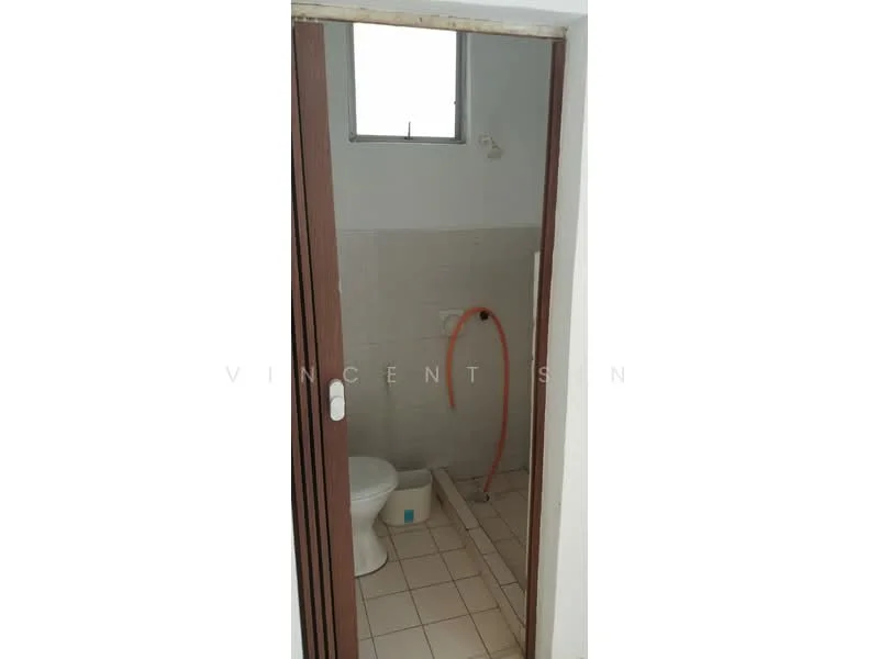 Bathroom features: white tiled walls, light grey tiled flooring, one-piece toilet, shower area with hose, small window, wooden door, plastic bucket.