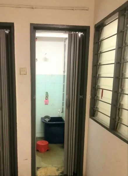Room features: white painted walls, grey door frames, sliding doors, tile flooring, window with metal grilles, blue plastic storage container, red plastic bucket, plumbing fixtures visible.
