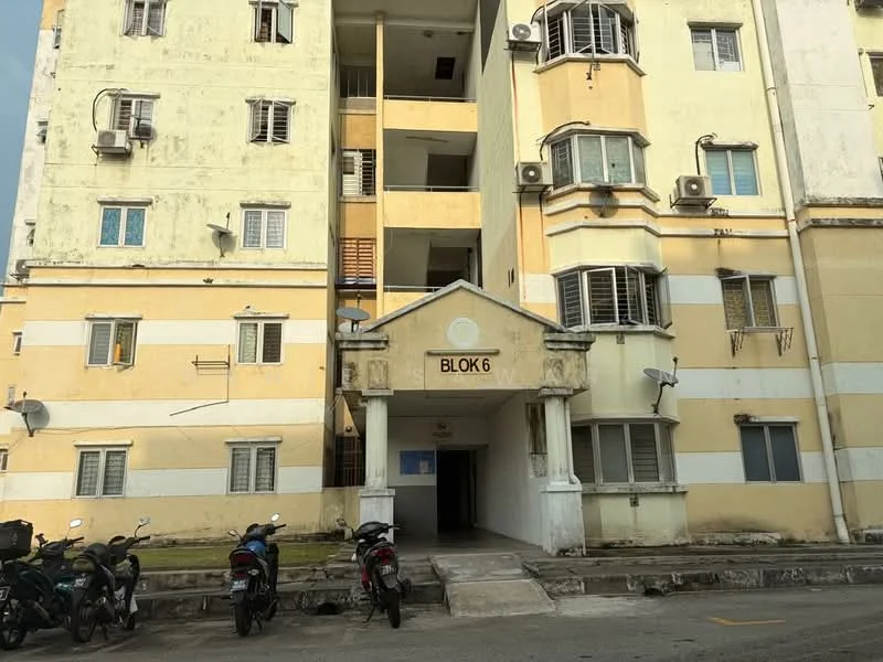 Exterior type: low-rise apartment block; features: yellow painted facade, white painted facade, balconies with metal railings, multiple air conditioning units visible, ground-level entrance, motorcycle parking area, windows with grilles, decorative archway at entrance; style: traditional.