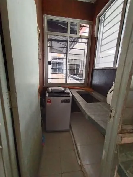 Laundry features: washing machine, grey countertop, single-bowl stainless-steel sink, white walls, tile flooring, window with grid pattern, natural light from window, shelving above countertop.