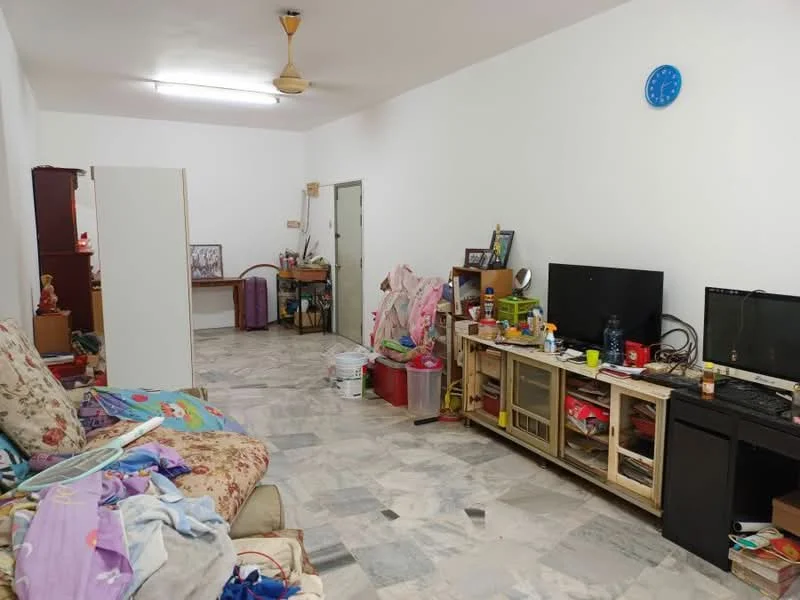 Living features: marble flooring, white painted walls, 5-blade ceiling fan, sofa with floral pattern, wooden TV console, wall-mounted TV, coffee table, decorative items on shelves, cluttered space with various items, study desk, multiple cushions and blankets.