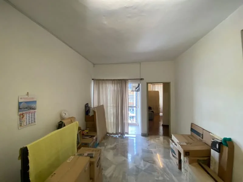 Room features: white painted walls, marble flooring, large window with sheer curtains, box storage, calendar on wall, furniture in boxes, neutral ceiling, doorway leading to another room.