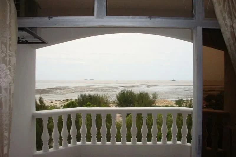 Room features: balcony with white railing, sea view, curtains, arched window, outdoor space; view: sea.