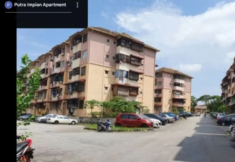Exterior type: low-rise apartment block; features: pink and beige painted facade, 3-storey building, balconies with railings, visible parking area, landscaped greenery, asphalt driveway, multiple parked vehicles, surrounding trees; style: modern.