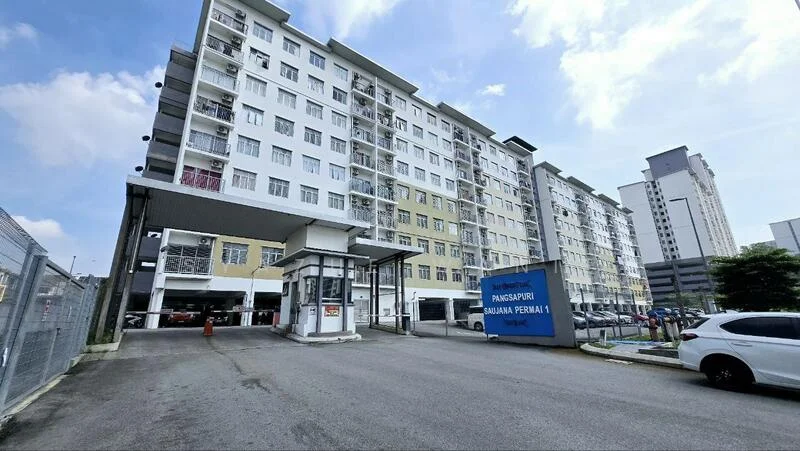 Exterior type: low-rise apartment block; features: multi-storey building, covered parking area, main entrance gate, security guard house, concrete facade, glass windows, yellow and white painted facade, surrounded by parking spaces, urban context with nearby buildings; style: modern.