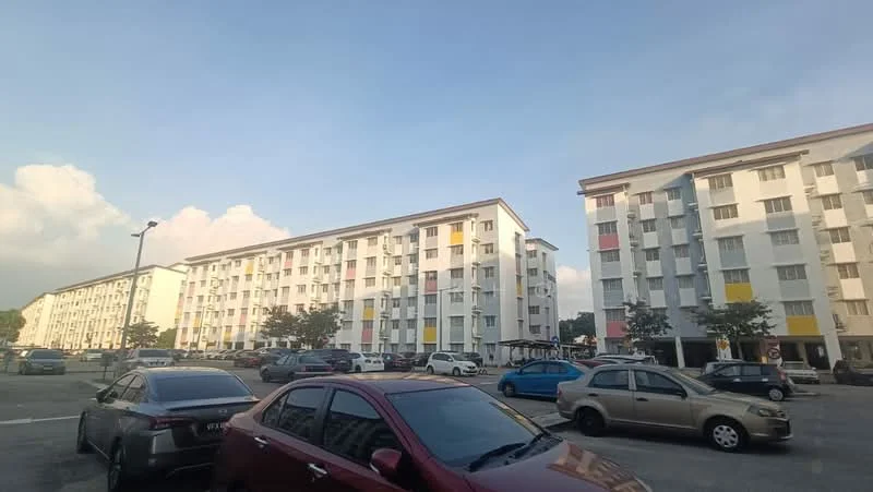 Exterior type: low-rise apartment block; features: white painted facade, colored accent panels, flat roof, approximately 3-storey, manicured landscaping, parking lot with multiple vehicles, surrounded by greenery; style: modern.