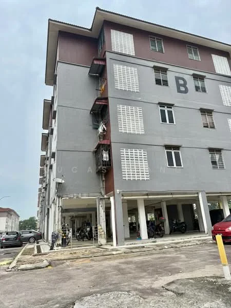 Exterior type: low-rise apartment block; features: grey painted facade, red accent panels, balconies with metal railings, window grilles, ground-level parking area, motorcycle parking, car parking spaces, multiple storeys, visible entrance area; style: modern.