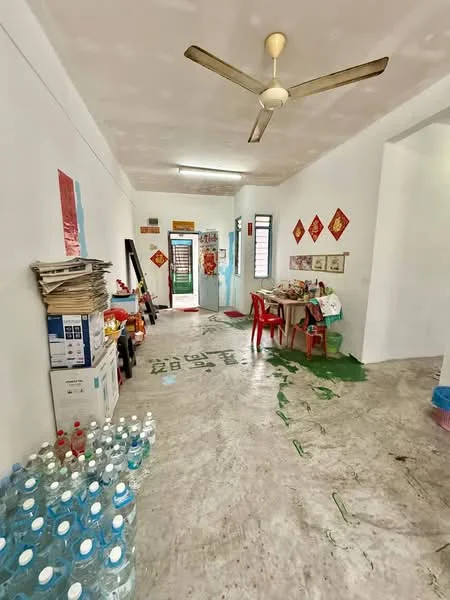 Room features: ceiling fan, marble flooring, white painted walls, wooden dining table, red plastic chairs, stacked water bottles, decorative wall art, green painted accents, open layout, doorway leading to another room; style: minimalist.